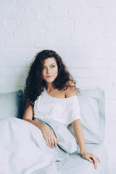 Happy woman sitting in bed during morning time at home — Stock Photo