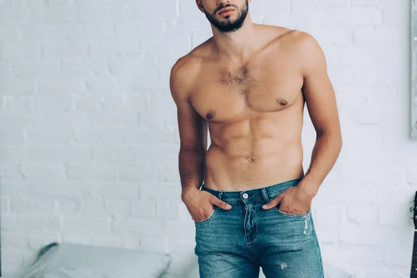 Partial view of shirtless man with muscular torso posing in bedroom at home — Stock Photo