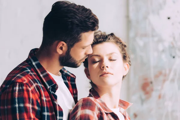 Foyer sélectif de l'homme en chemise à carreaux étreignant petite amie à la maison — Photo de stock