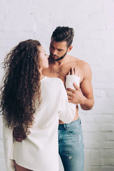 Rear view of curly beautiful woman embracing boyfriend at home — Stock Photo