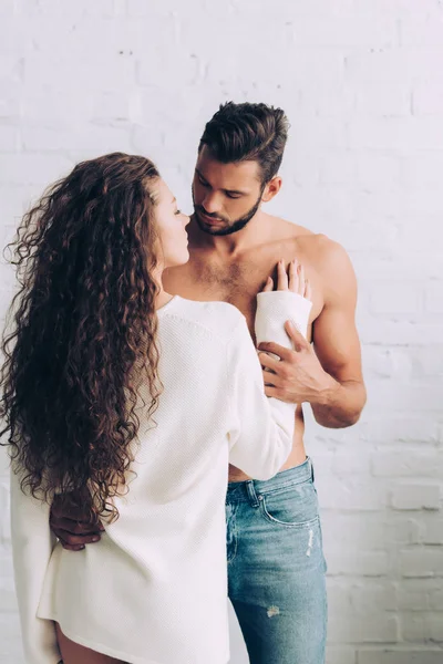 Visão traseira da mulher bonita encaracolado abraçando namorado em casa — Fotografia de Stock