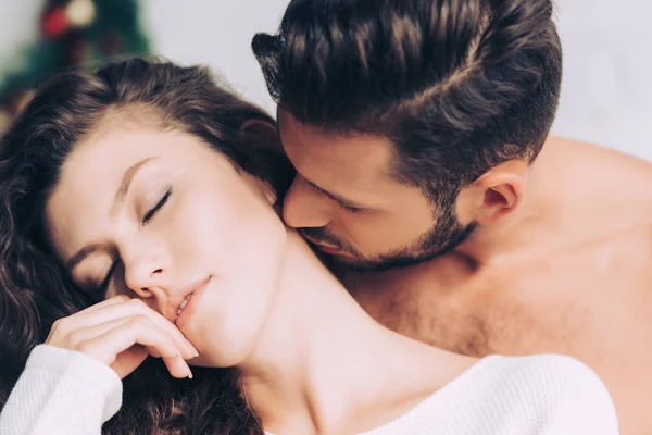 Крупным планом видно, как мужчина целует красивую подругу в шею — стоковое фото