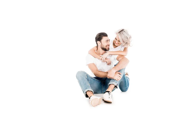 Wunderbares Paar, das sich umarmt, während es isoliert auf weiß sitzt — Stockfoto