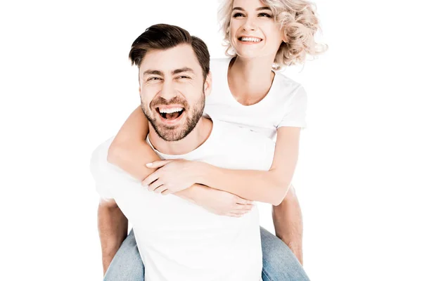 Couple heureux s'amuser tandis que l'homme donnant piggyback à la femme isolée sur blanc — Photo de stock