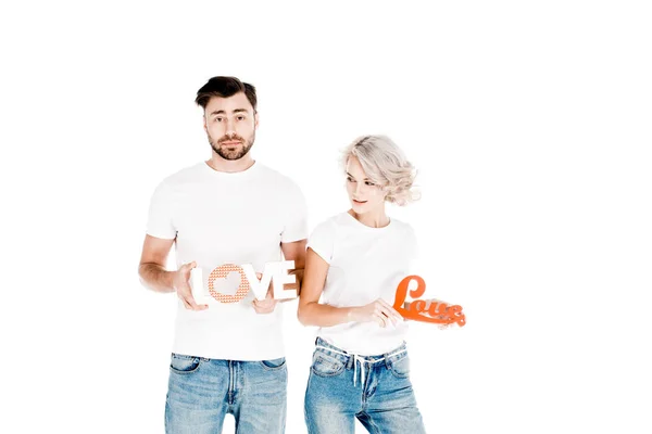 Gran pareja atractiva sosteniendo signos de amor aislado en blanco - foto de stock