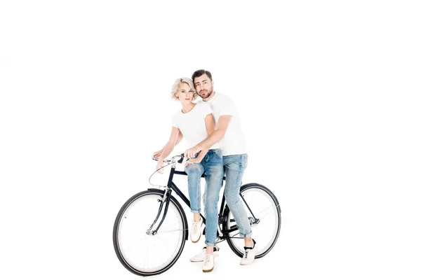 Fantástica pareja abrazándose mientras montan en bicicleta juntos aislados en blanco - foto de stock