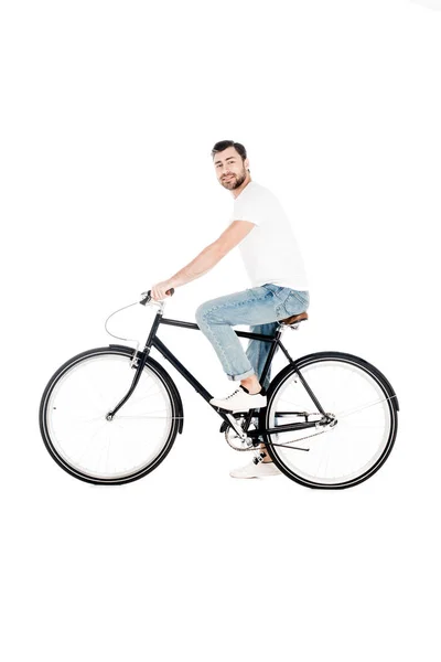 Bonito sorridente jovem adulto andar de bicicleta enquanto olha para a câmera isolada no branco — Fotografia de Stock