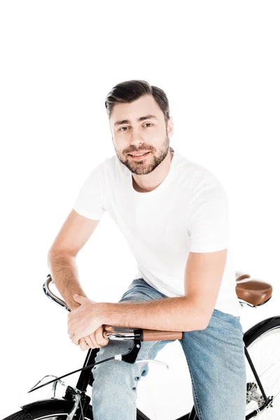 Handsome smiling young adult man riding bicycle isolated on white — Stock Photo