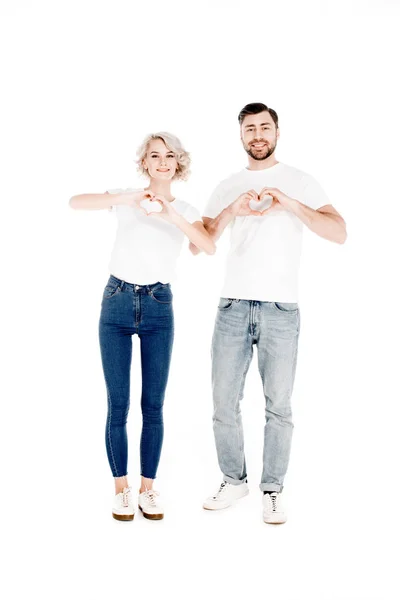 Усміхнена красива молода пара дорослих, що показує жест форми серця з пальцями любові ізольована на білому — стокове фото