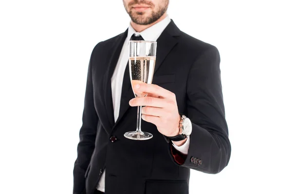 Teilansicht eines Mannes im schwarzen Kostüm, der ein Glas Champagner auf Weiß hält — Stockfoto