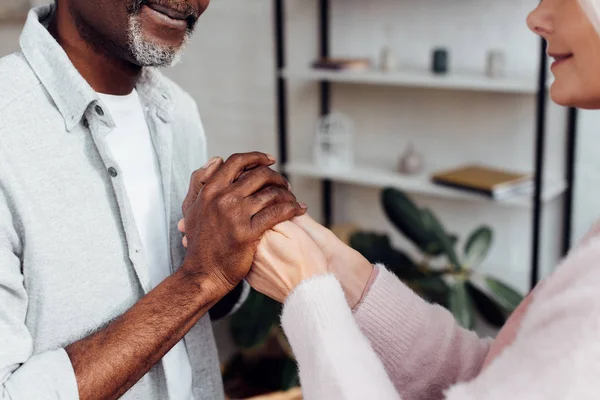Nahaufnahme einer reifen Frau und eines afrikanisch-amerikanischen Mannes beim Händchenhalten — Stockfoto