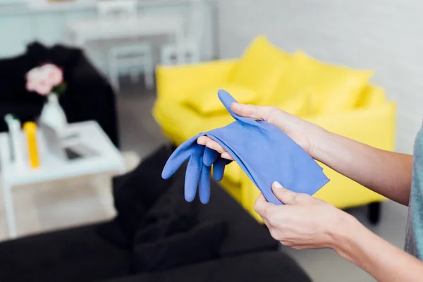 Primer plano de las manos femeninas sosteniendo guantes de goma azul - foto de stock