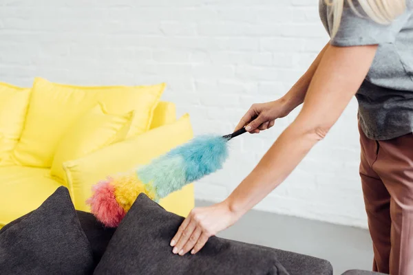 Gros plan des mains féminines tenant un plumeau multicolore — Photo de stock
