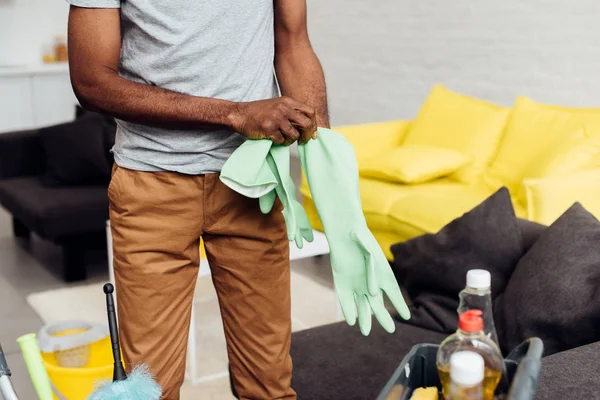 Vue recadrée de l'homme afro-américain mettant des gants en caoutchouc — Photo de stock