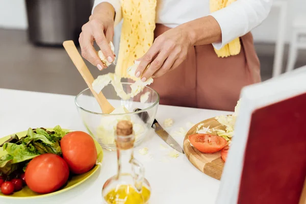 Close up of female hands putting cabbage in bowl for salad — Stock Photo