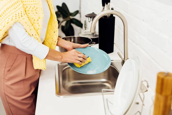 Close up of female hands washing dishes at kitchen — Stock Photo