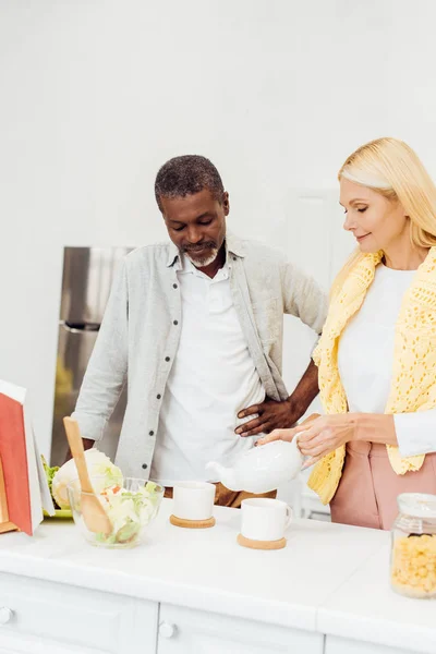 Mature couple drinking tea together at kitchen — Stock Photo