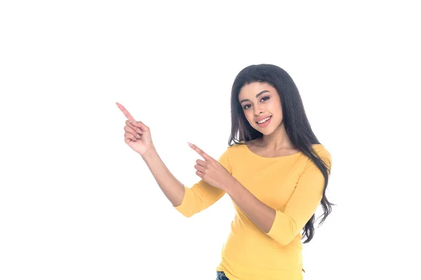 Menina americana africana feliz apontando para longe com os dedos e sorrindo para a câmera isolada no branco — Fotografia de Stock