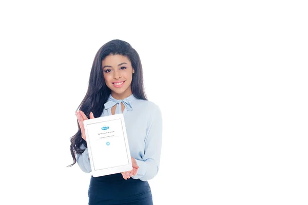 Hermosa joven afroamericana mujer sosteniendo tableta digital con aplicación de skype en la pantalla y sonriendo a la cámara aislada en blanco - foto de stock