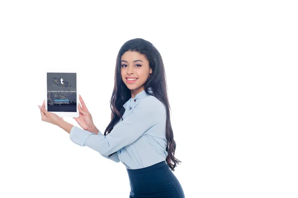 Beautiful young african american woman holding digital tablet with tumblr application on screen and smiling at camera isolated on white — Stock Photo