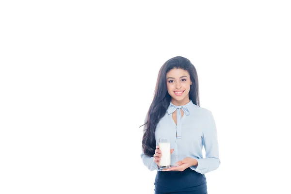 Hermosa joven afroamericana mujer sosteniendo un vaso de leche y sonriendo a la cámara aislada en blanco - foto de stock