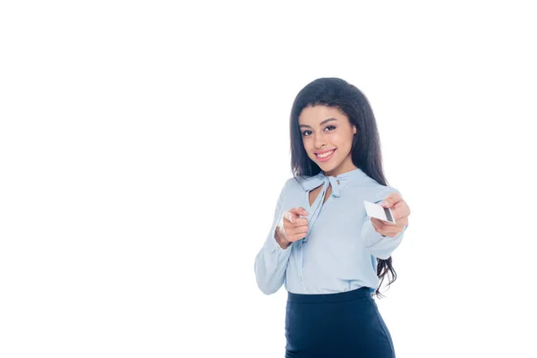 Sonriente joven afroamericana mujer sosteniendo tarjeta de crédito y apuntando a la cámara aislada en blanco - foto de stock