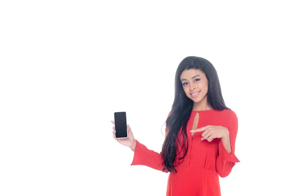 Африканская американка в красном платье указывает на смартфон с пустым экраном, изолированным на белом — стоковое фото