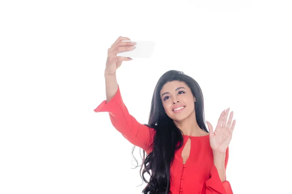 Lächelnder Afroamerikaner in rotem Kleid macht Selfie auf Smartphone und winkt mit der Hand isoliert auf weißem Hintergrund — Stockfoto