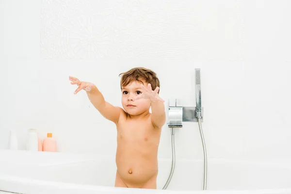 Small boy gesturing in white bathroom — Stock Photo