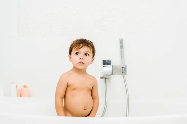 Small boy standing in white clean bathroom — Stock Photo