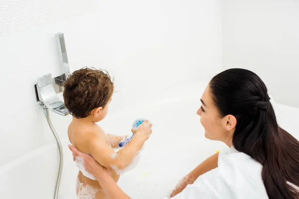 Brunette mother and toddler boy in white bathroom — Stock Photo