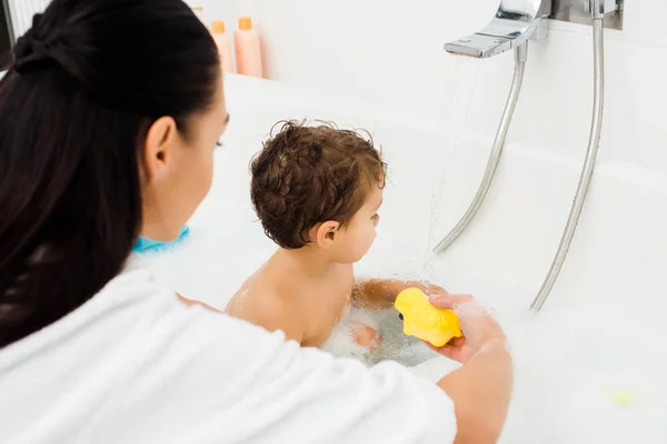 Brunette woman and toddler boy in white bathroom — Stock Photo