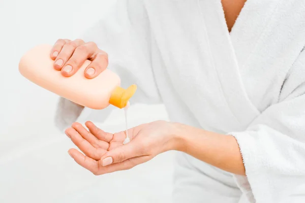 Primer plano de la mujer que aprieta la loción en la mano aislada en blanco - foto de stock