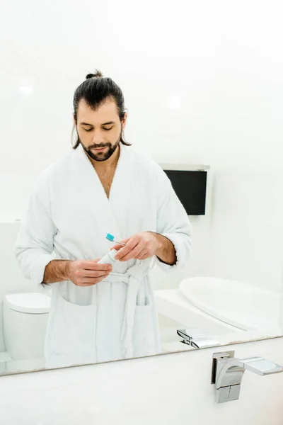 Bel homme adulte se préparant à brosser les dents dans la salle de bain — Photo de stock