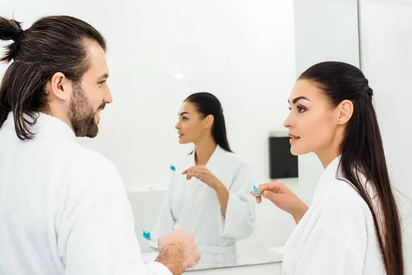 Young couple brushing teeth together at morning in bathroom — Stock Photo