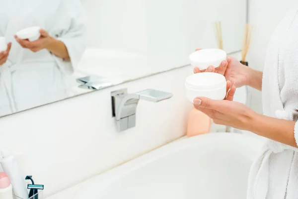 Primo piano di mani femminili che tengono la crema per il corpo — Foto stock