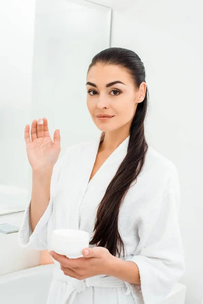 Femme avec une peau parfaite montrant crème visage sur les doigts — Photo de stock