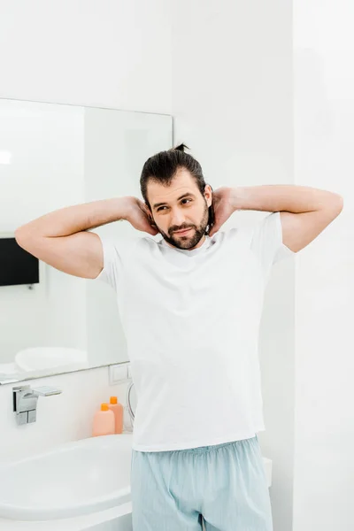 Handsome man stretching in bathroom at morning — Stock Photo