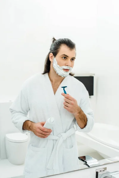 Homem de roupão de banho branco barbear na frente do espelho — Fotografia de Stock