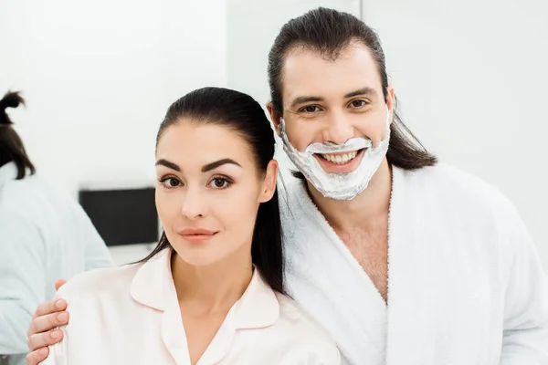 Nahaufnahme eines süßen lächelnden Paares in weißen Bademänteln — Stockfoto