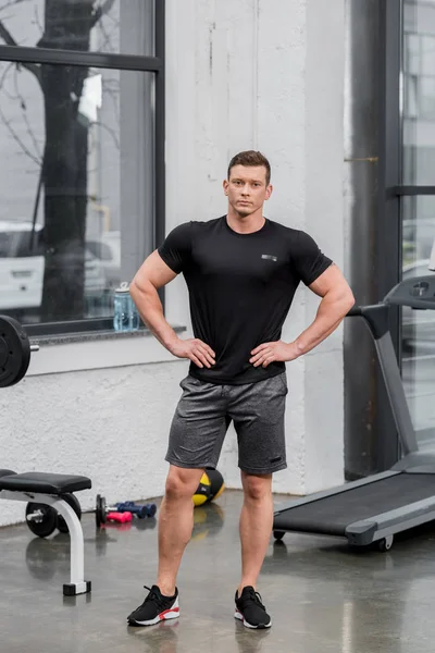 Gutaussehender muskulöser Bodybuilder schaut in Turnhalle in die Kamera — Stockfoto