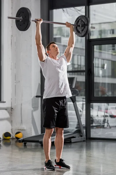 Entraînement sportif de bodybuilder athlétique avec haltère dans le gymnase — Photo de stock