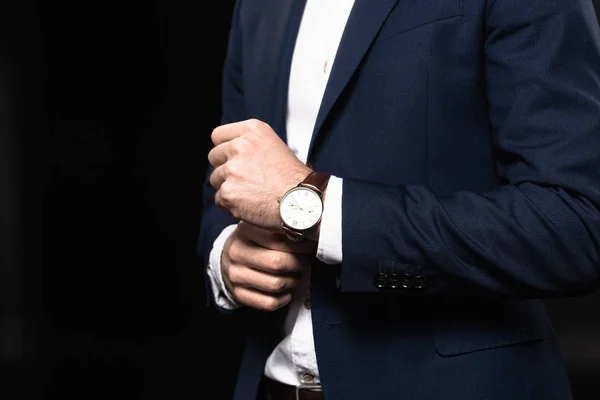 Cropped shot of businessman in stylish suit with wrist watch isolated on black — Stock Photo