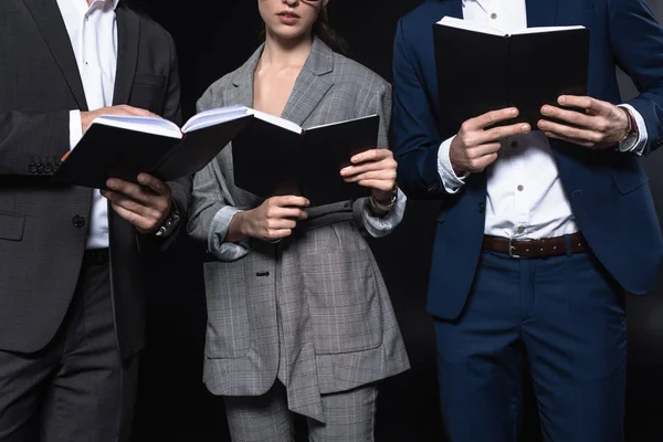 Plan recadré de groupe de gens d'affaires travaillant avec des ordinateurs portables ensemble isolé sur noir — Photo de stock