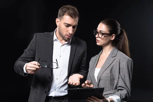 Business people with clipboard having conversation isolated on black — Stock Photo