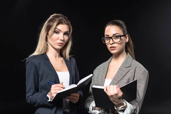 Confident young businesswomen isolated on black — Stock Photo
