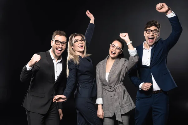 Grupo de empresarios exitosos celebrando la victoria aislados en negro - foto de stock