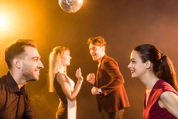 Happy young couples dancing and looking at each other during party — Stock Photo