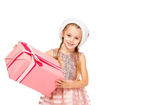 Entzückendes kleines Kind in Weihnachtsmannmütze mit Geschenkverpackung und Blick in die Kamera isoliert auf weiß — Stockfoto