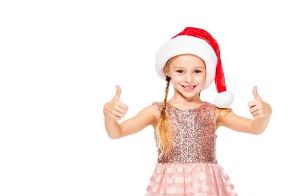 Adorable little child in santa hat showing thumbs up isolated on white — Stock Photo